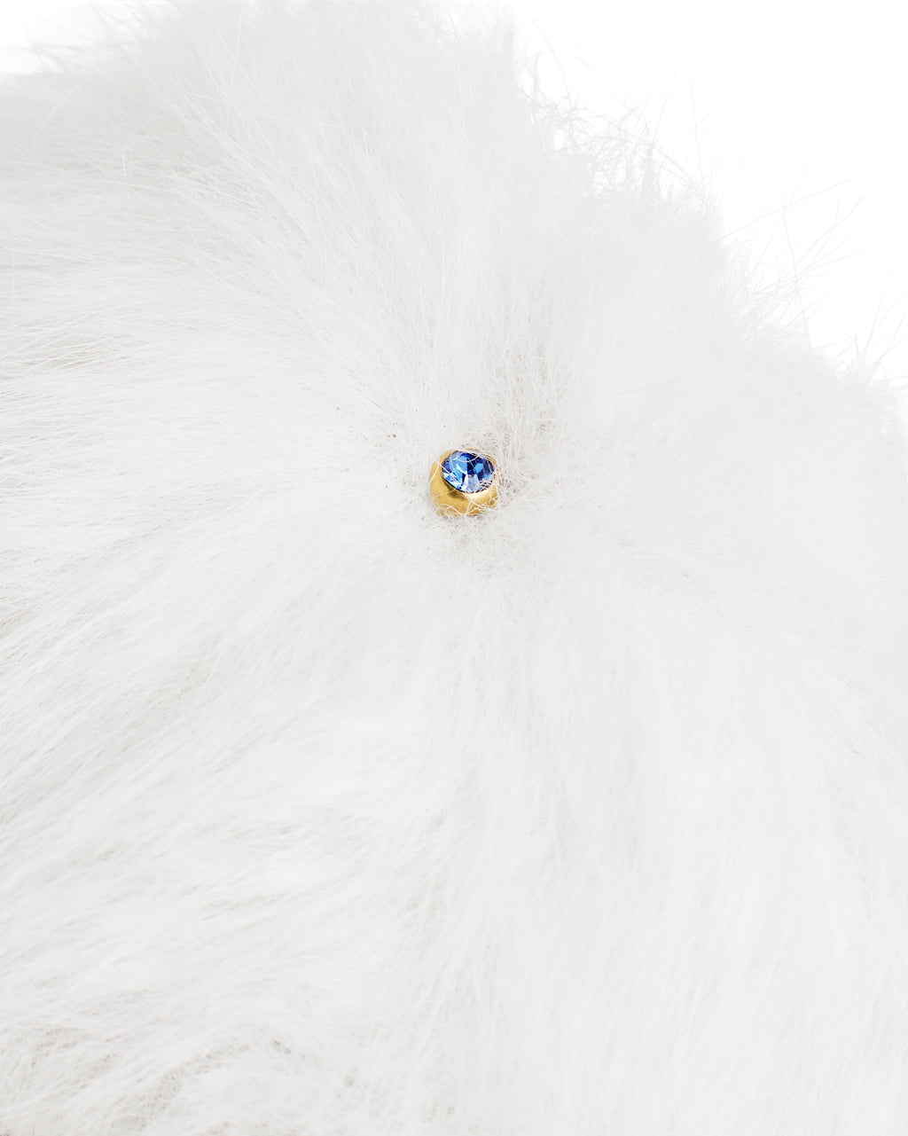 Detalhe do pingente em cristal azul na faixa de pelo branco do chinelinho da linha Serenitá Benvenuta.