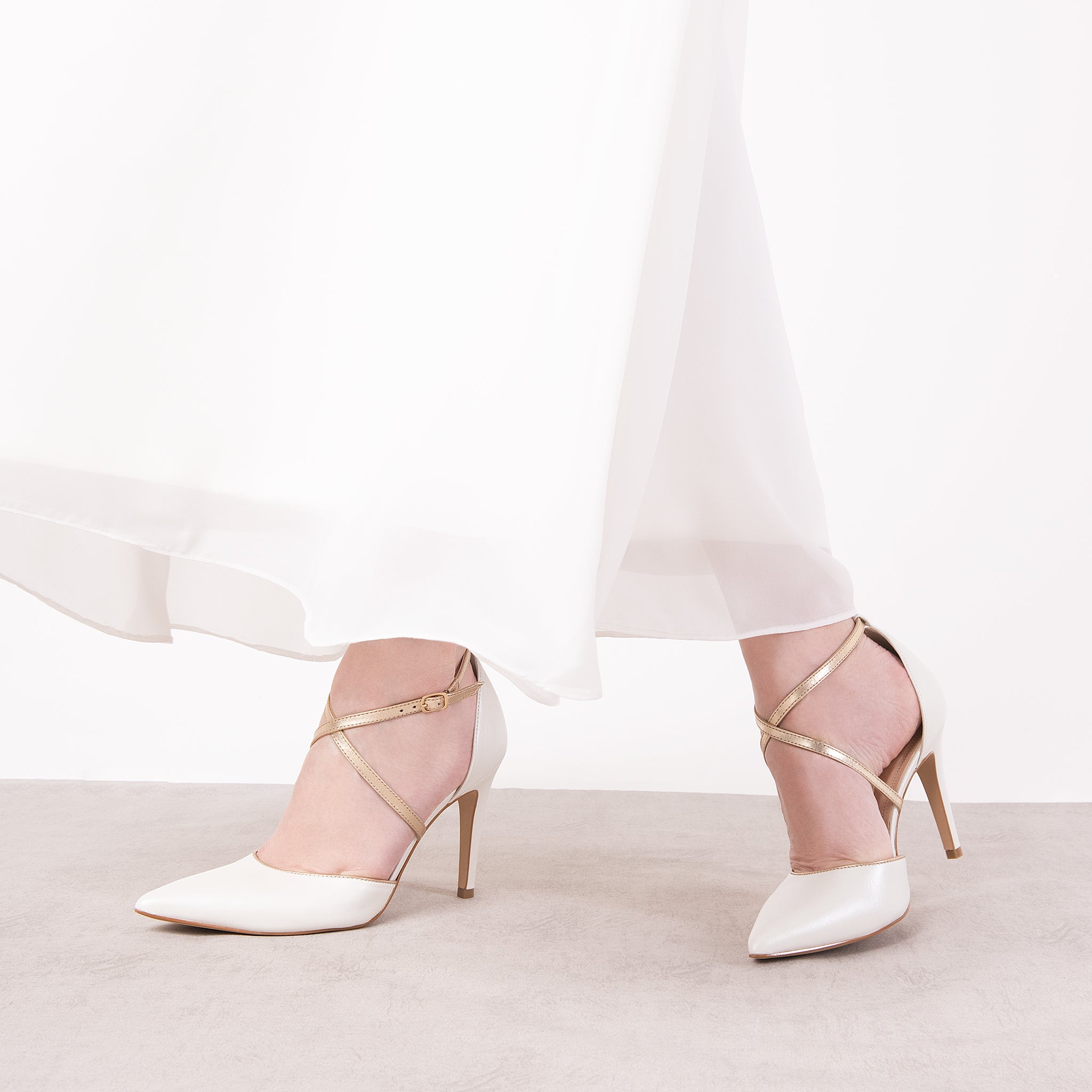 SAPATO DE NOIVA TIPO SCARPIN DE BICO FINO E SALTO ALTO FINO NA COR BRANCA PEROLIZADA COM TIRAS TRANÇADAS NA COR CHAMPAGNE