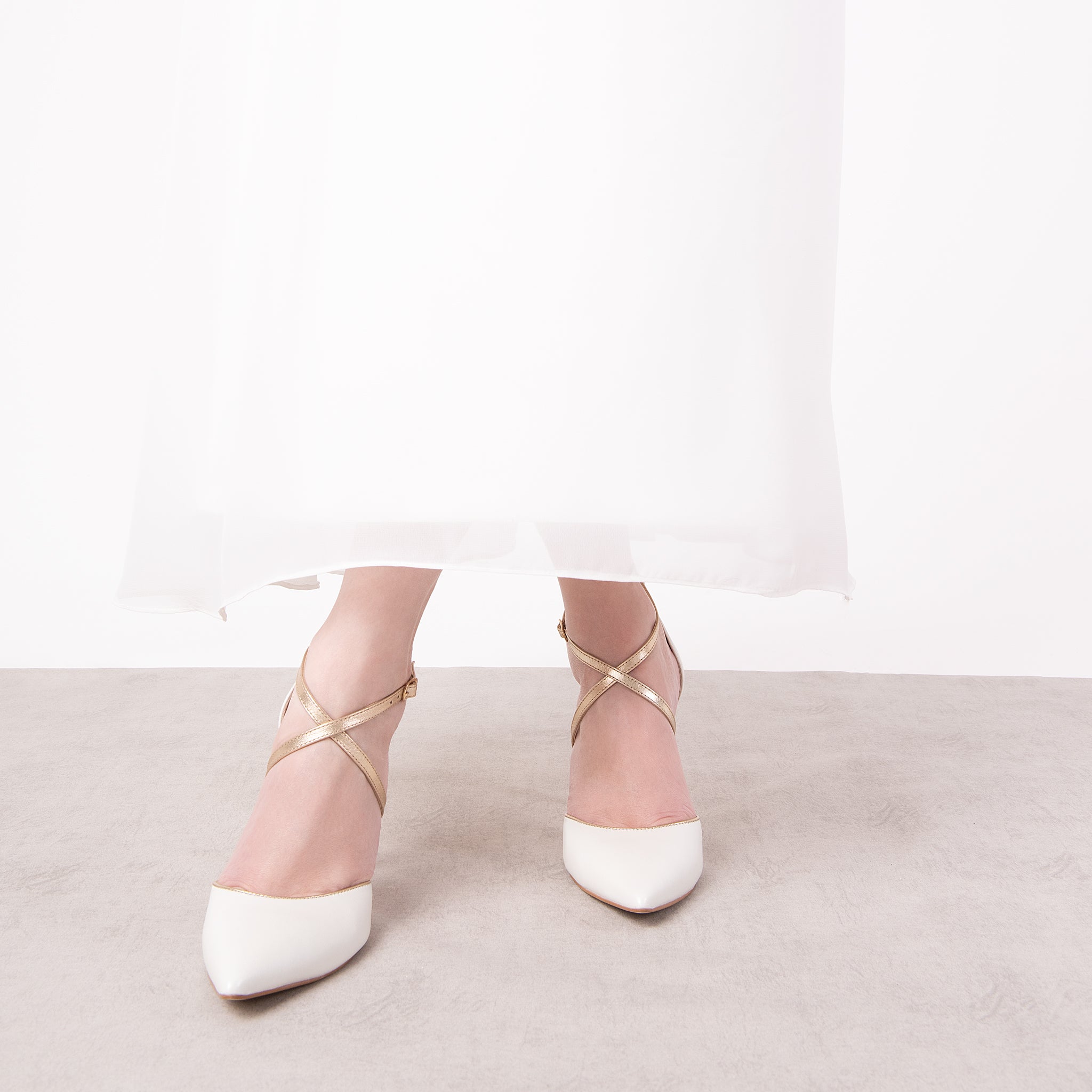 SAPATO DE NOIVA TIPO SCARPIN DE BICO FINO E SALTO ALTO FINO NA COR BRANCA PEROLIZADA COM TIRAS TRANÇADAS NA COR CHAMPAGNE