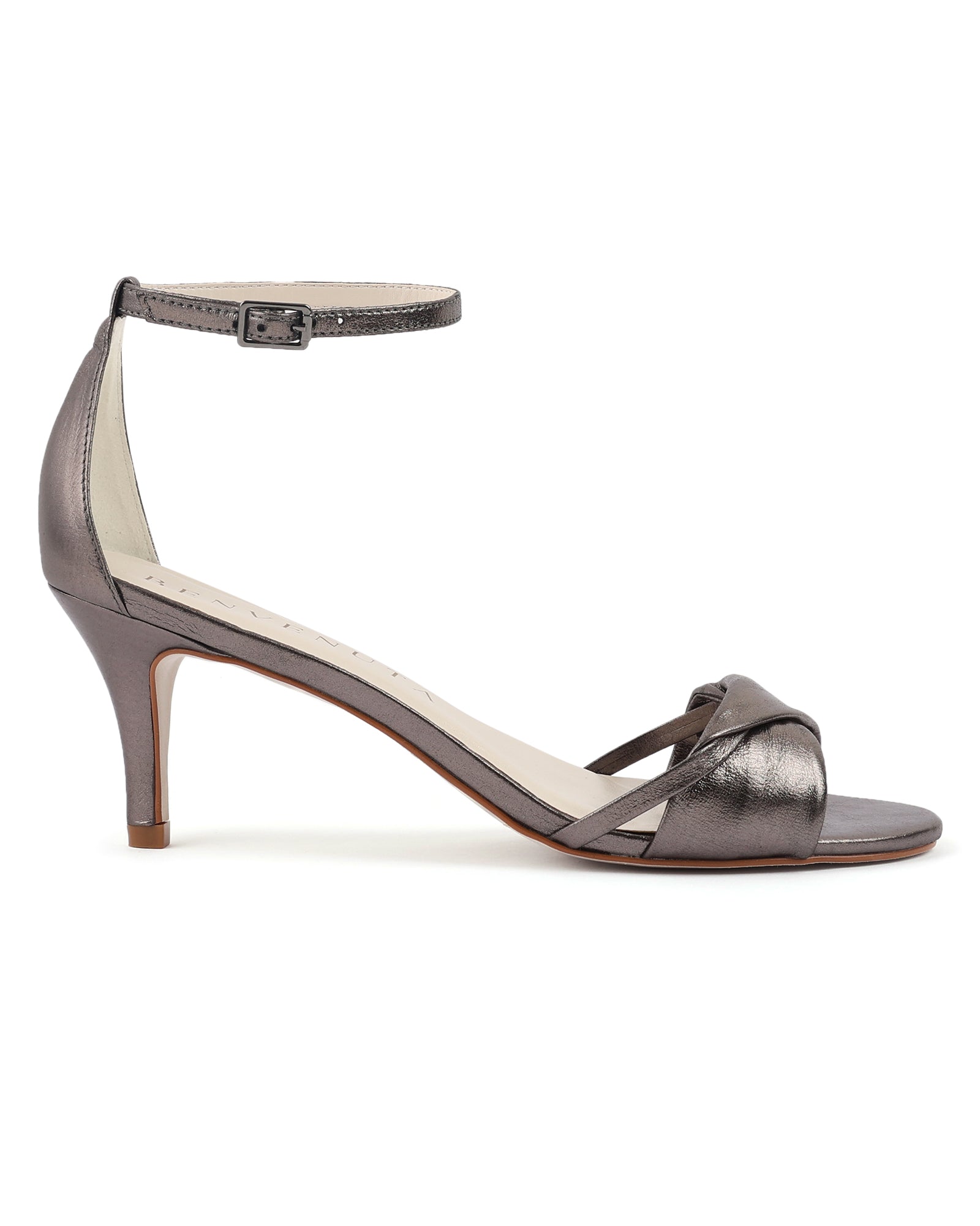 Sandália Vera 70 carbono metalizada com salto fino de 7 cm, vista lateral.
Sandália de festa em couro metalizado cinza escuro, com tira torcida e pulseira no tornozelo.