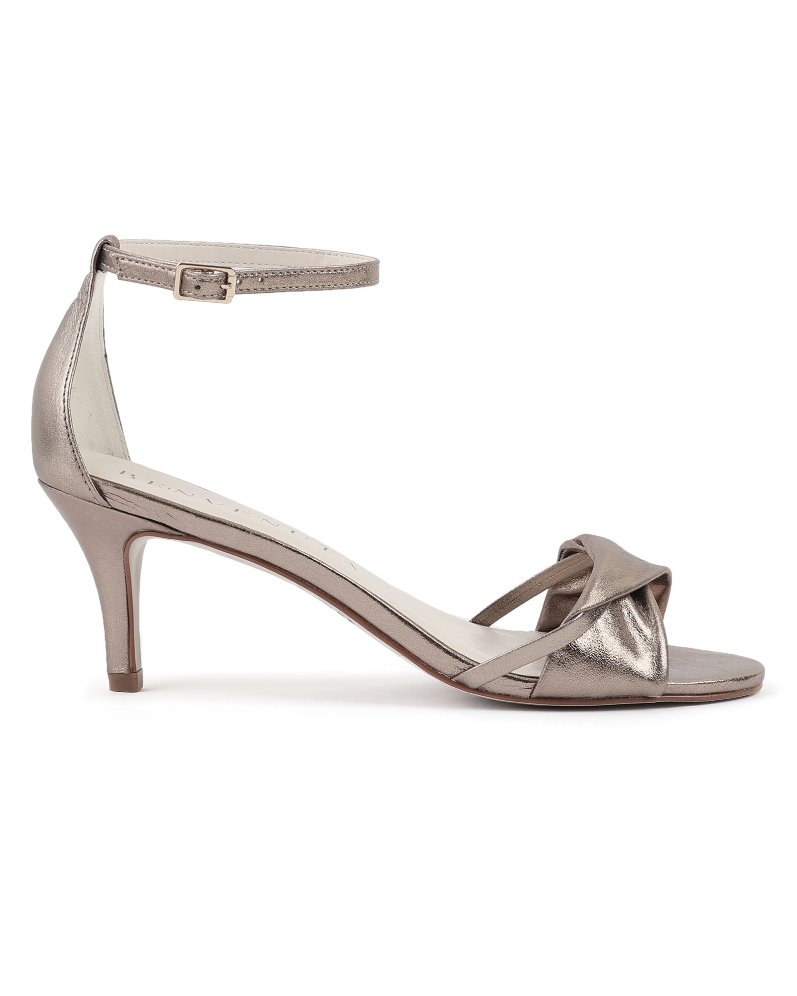 Sandália Vera 70 prata velho com acabamento metalizado e salto fino de 7 cm. Sapato de festa versátil em tom neutro, com tira torcida e fecho no tornozelo.