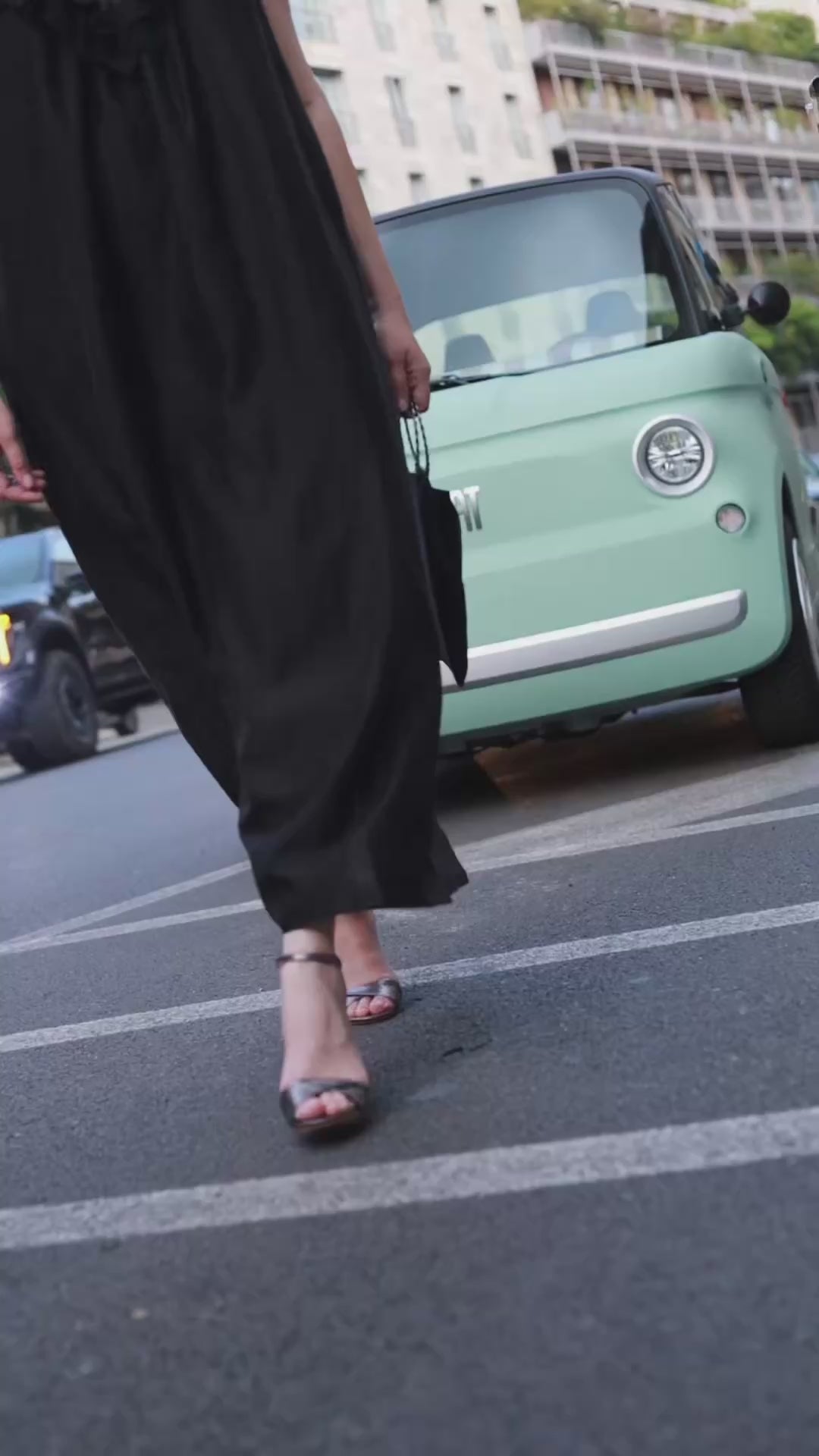 Sandália Vera 70 carbono metalizada com salto fino de 7 cm, vista lateral.
Sandália de festa em couro metalizado cinza escuro, com tira torcida e pulseira no tornozelo.